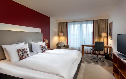 多特蒙德多特蒙德威斯特法伦哈伦多瑞特酒店的酒店客房设有一张白色大床和一张书桌