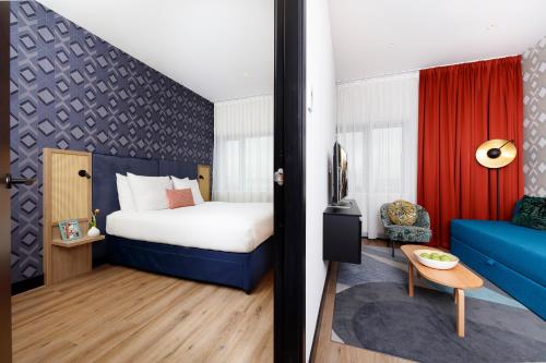 阿姆斯特丹Citadines Sloterdijk Station Amsterdam的酒店客房,配有床和蓝色的沙发