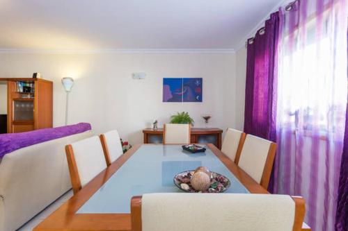 法鲁Rooms_Heart Apartment的一间设有桌子和紫色窗帘的用餐室