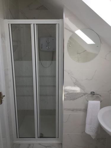 MervynSt Anthony's Rosslare Strand的一间带玻璃淋浴和水槽的浴室