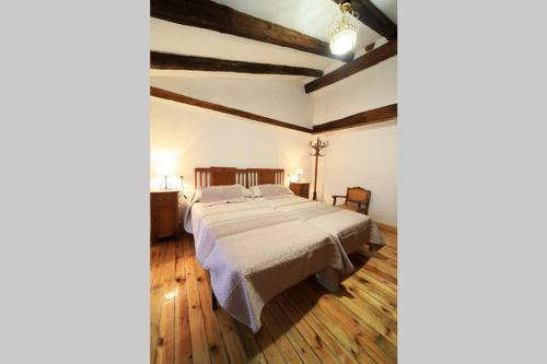 索里亚Piedra Andadera II的一间卧室设有一张大床,铺有木地板。