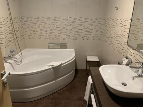 圣弗朗西斯科尔坎姆都灵机场公寓式酒店的白色的浴室设有浴缸和水槽。