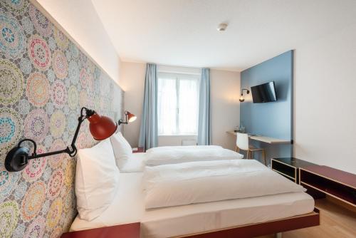 索洛图恩Bären Self Check-in Hotel的酒店客房,设有两张床和一盏灯