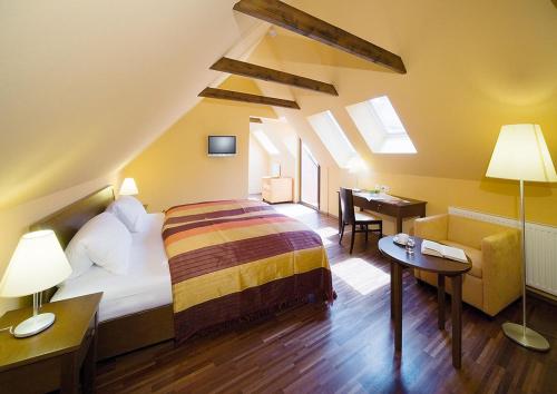 巴特拉德克斯堡Sporer Stadthotel Bad Radkersburg的一间卧室配有一张床和一张书桌
