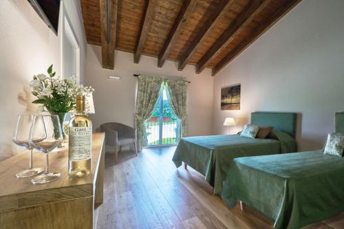  TassaroloFORESTERIA DEL GAVI的酒店客房带两张床和一瓶葡萄酒
