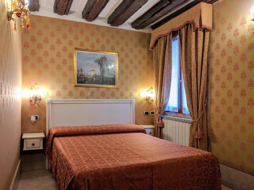 威尼斯卡圣比欧酒店的一间卧室设有一张床和一个窗口