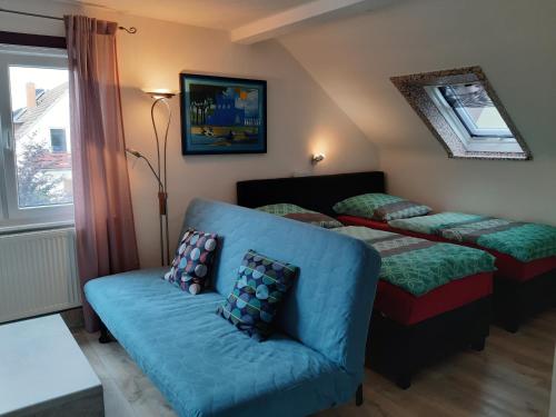 汉诺威Ferienwohnung Jasmin的客房设有两张床、一张沙发和一个窗口。