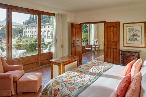 菲耶索莱Villa San Michele, A Belmond Hotel, Florence的卧室配有床、椅子和窗户。