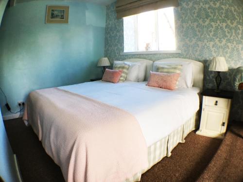 克雷迪顿Hillside Bed and Breakfast的卧室配有带粉红色枕头的大型白色床