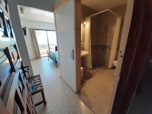 Estepona布埃纳维斯塔酒店的走廊设有带淋浴的浴室和门