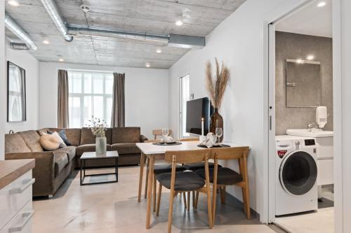 奥勒松Aalesund City Apartment的厨房以及带桌椅的起居室。