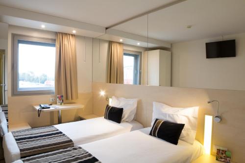 加亚新城波尔图盖亚公园酒店的酒店客房,设有两张床和镜子