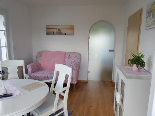 布兰肯海姆Ferienwohnung Pfeil的客厅配有桌子和粉红色的沙发