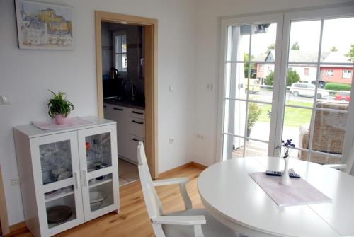 布兰肯海姆Ferienwohnung Pfeil的厨房配有桌子和白色的桌椅