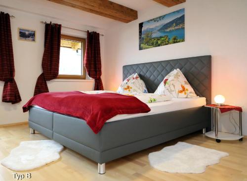 滨湖采尔Chalet Der Bichlhof的一间卧室配有一张带红色毯子的大床