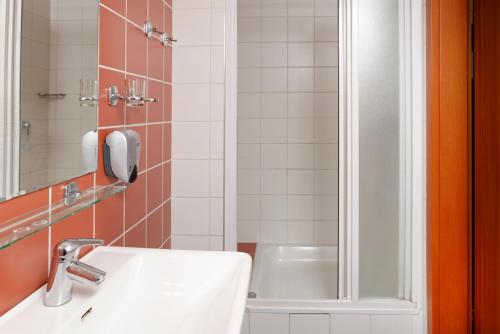 塔查斯卡-鲁穆尼卡Hotel Tulipan的一间带水槽和淋浴的浴室