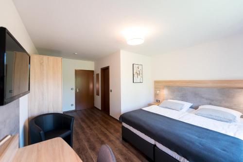 明斯特Hotel Hüerländer的酒店客房配有一张床铺和一张桌子。