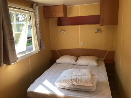 吉伦特河畔梅谢尔Mobil Home à Meschers au camping l'Escale proche de Royan的一间小卧室,配有床和窗户