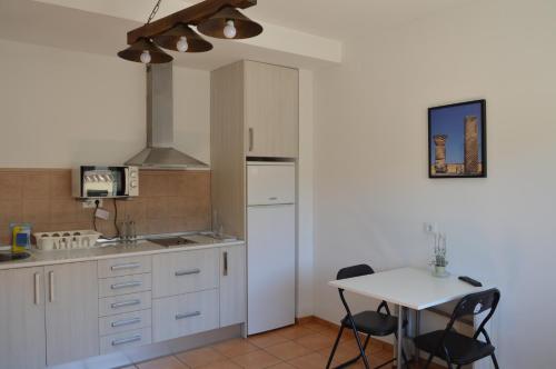 ReílloRural Reillo Alojamientos Rurales的厨房配有白色橱柜和桌椅