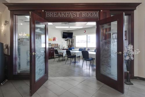 尼斯库Ramada by Wyndham Nisku Edmonton Airport的餐厅设有早餐室,配有桌椅