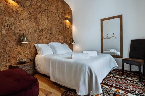 埃武拉Alfar Story - Évora House的卧室配有一张白色大床和镜子