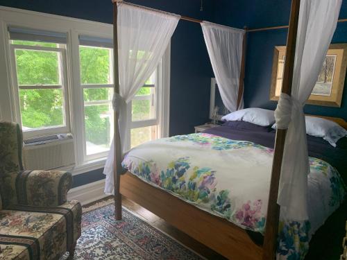 滨湖尼亚加拉Green Oaks B&B的一间卧室配有一张床、一把椅子和窗户。