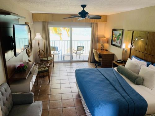 Lindbergh Bay翡翠海滩度假村的一间卧室配有一张床,客厅设有阳台