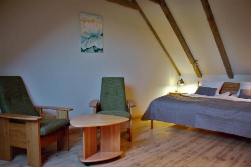 泰尔韦泰Blankenfeldes muiža的一间卧室配有一张床、两把椅子和一张桌子
