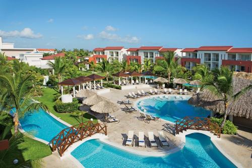 蓬塔卡纳Dreams Royal Beach Punta Cana - All Inclusive的享有带椅子和遮阳伞的度假村游泳池的空中景致
