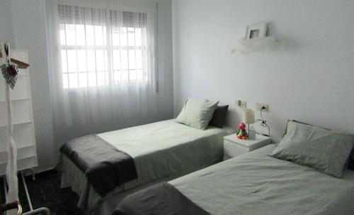 普里埃格·德·科尔多巴La Casa de Maribel的一间卧室设有两张床和窗户。