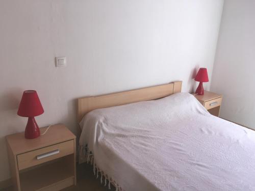 L'EspérouAppartement l'Espérou的一间卧室配有一张床和两张台灯。