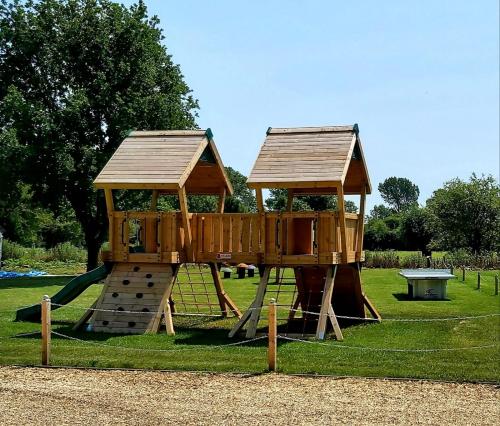 WorminghallThe Clifden Arms B&B的公园内一个带木游戏结构的游乐场