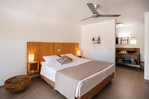 威利布罗德Kas Amigu accomodations的一间卧室配有一张床和吊扇