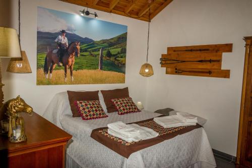 英雄港Quinta do Malhinha- Turismo的卧室,卧室配有一张带一幅马夫画的床