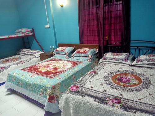 麻坡Homestay Roomstay Muar Srizahrani的卧室设有两张床铺和蓝色的墙壁