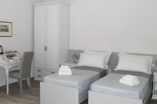 波蒂奇L'Acchiappasogni Vesuviano Guest House的一间卧室配有两张床、一张桌子和一个橱柜