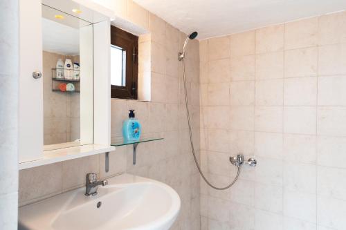 Asklipiḯon1900's traditional house in Asklipio的浴室配有盥洗盆和带镜子的淋浴