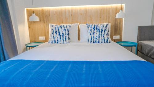 古瓦伊Anfi Suites的一张蓝色和白色的大床,配有蓝色和白色的枕头