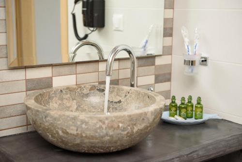 阿莫尔戈斯Οasis Apartments的浴室内带水龙头的石水槽