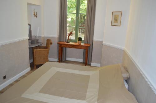 蒙布兰莱班Appartement Bellevue du Ventoux的客房设有床、桌子和窗户。