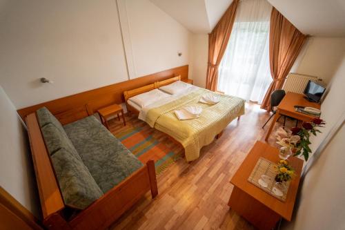 斯米扎尼Park Hotel Čingov的一间带床和沙发的小卧室