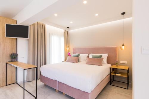 (( Agía Eleoúsa ))V Luxury Suites的一间卧室配有一张大床和电视