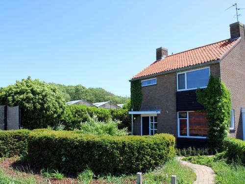 柯德科克Holiday Home Moesbosch by Interhome的红屋顶和灌木的砖屋