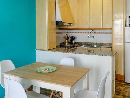 圣卡洛斯拉腊皮塔Apartment Maricin by Interhome的厨房配有木桌和白色椅子