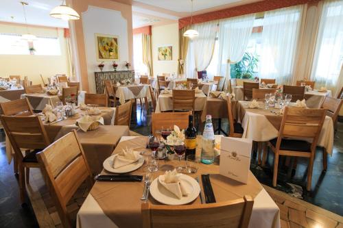 费德拉帕加内拉法依酒店的一间设有白色桌椅的餐厅