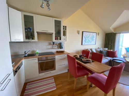 布雷拉Werz Sea View Apartment的厨房以及带桌子和红色椅子的客厅。