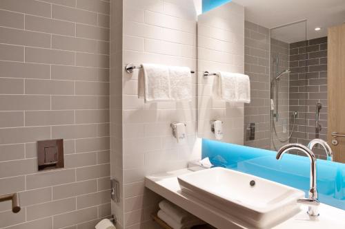 慕尼黑Holiday Inn Express Munich - Olympiapark, an IHG Hotel的白色的浴室设有水槽和淋浴。