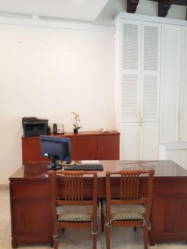 马六甲麒麟海峡酒店 的办公室,配有一张桌子、一台电脑和两把椅子