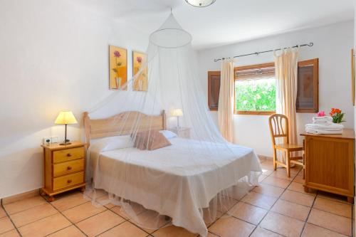 圣埃乌拉利亚Casa Es Pins的一间卧室配有一张带蚊帐的床