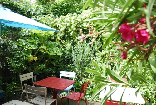 图尔米拉波酒店的花园里种着鲜花,摆放着红色的桌子和椅子